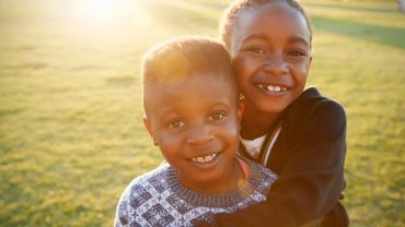 african-elementary-school-boy-and-girl-hugging-PWEPJ7F.jpg